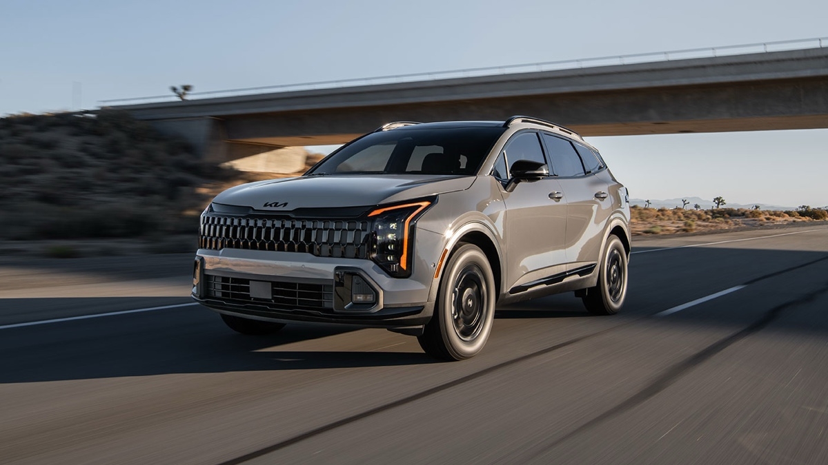 Kia Sportage 2025 roulant sur l’autoroute dans un décor désertique, démontrant son design audacieux et ses performances dynamiques.