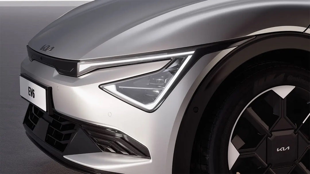 Gros plan du phare avant de la Kia EV6 2025 en gris, soulignant la finesse du design et la technologie d’éclairage moderne.