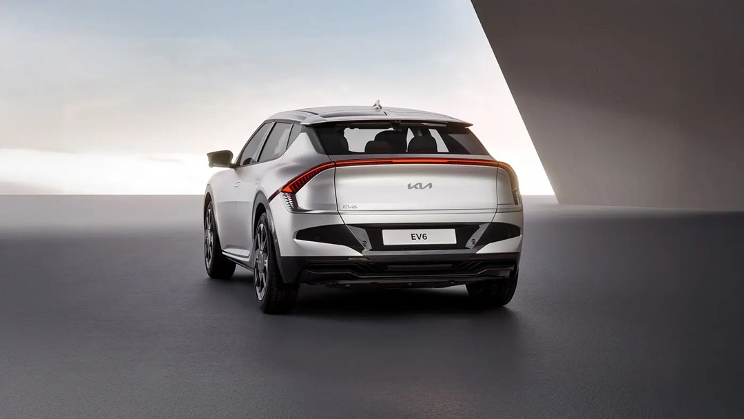 Vue arrière de la Kia EV6 2025 en gris argenté, mettant en valeur sa signature lumineuse horizontale et son design sculpté.