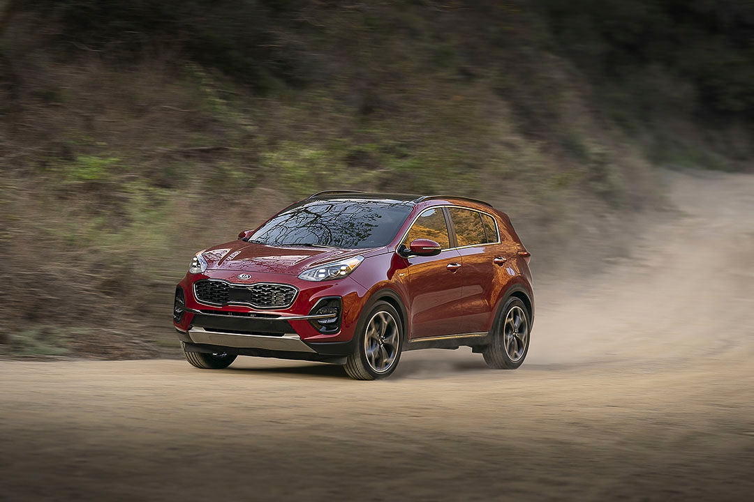 Vue trois quart avant du Kia Sportage 2021 sur une route de terre